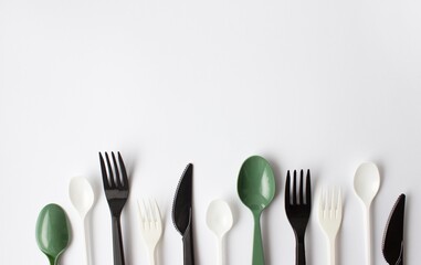 Color plastic cutlery on a white background. Place for text. Environmental problem, environmental pollution. 