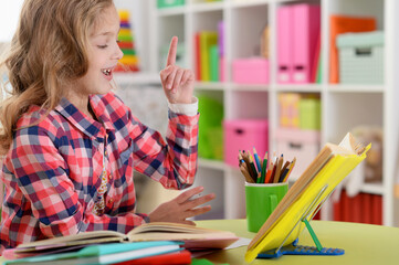 Cute teen girl doing homework in her room