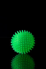Green rubber ball on black background