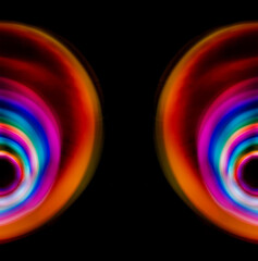 Multicolored light circles of different colors, yellow blue, red, blurred circle on a black background, photo was taken with a long exposure when the lanterns of rainbow colors were twisted