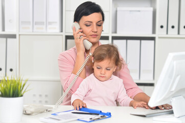 Portrait of  businesswoman with her child  working in office