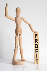 The wooden man raised his hand, and under his left hand he has cubes with the inscription - PROFIT