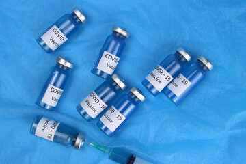 Ampoules of the coronavirus vaccine injection on a blue background. Top view