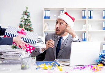 Young businessman celebrating christmas in the office