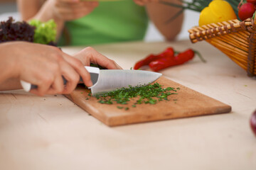 Close-up of human hands cooking vegetables salad in kitchen. Healthy meal and vegetarian concept