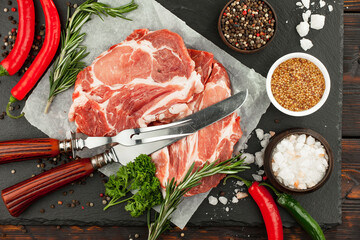Raw meat with spices in a composition with kitchen accessories.