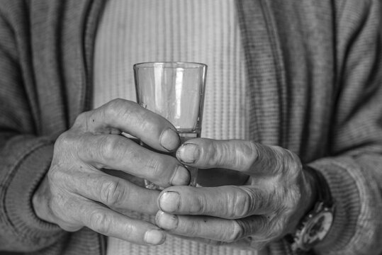 Old man holds a cachaca glass