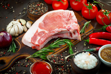 Raw meat with spices in a composition with kitchen accessories.