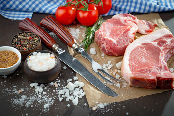 Raw meat with spices in a composition with kitchen accessories.