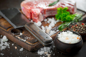 Raw meat with spices in a composition with kitchen accessories.