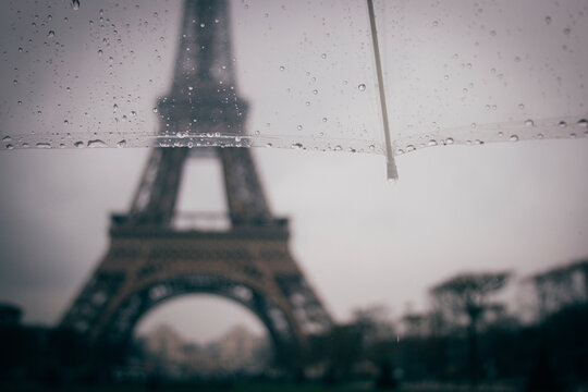 Cropped image of umbrella against Eiffel Tower during rainy season