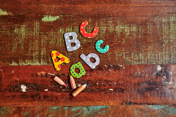 Auburn wooden table with colorful letters that make up the term ABC.