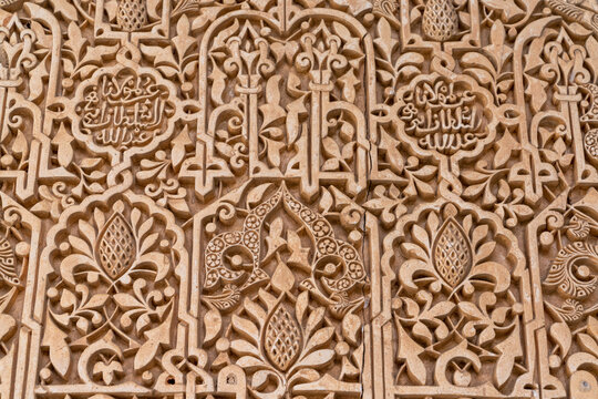 close up view of detailed carving and Arabic calligraphy work in the Alhambra