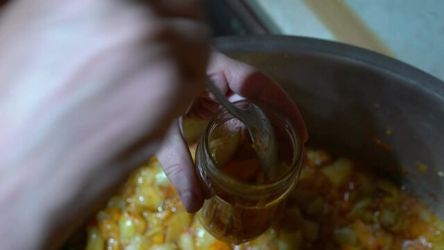 Pouring homemade mixed vegetable (G&uuml;ve&ccedil;) into sterile jars - (4K)
