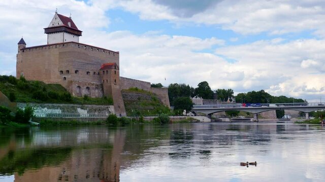 Beautiful city scenery, historic landmark on Russian Estonian border, Narva Herman castle on banks of Narva river, cloudy sky skyline