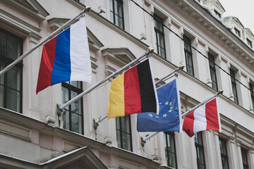 Flags of Russia, Germany, the European Union and Austria on the wall of an old stone building