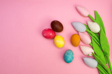 Easter background with painted eggs and colorful tulips. Top view with copy space