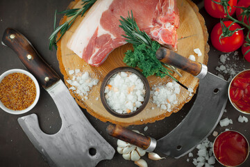 Raw meat with spices in a composition with kitchen accessories.