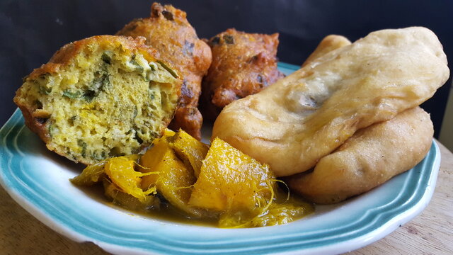 A plate of Trinidad and Tobago's Aloo or potato pies, Saheena (Sahina), and cut up Curried Mangoes. The potato pies are one on top of the other. Traditional Street Food.	