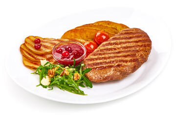 Grilled beef steak with potato wedges, grilled pears and arugula salad with feta cheese, isolated on white background