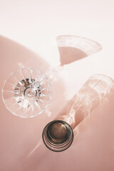 Wine glass or glass on a pink background with long shadow from sunlight in a minimal style.