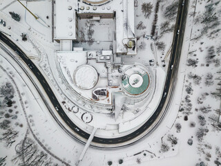 Snowy Kiev. A curved road near a house with a round roof. Aerial drone view. Winter snowy morning.