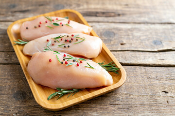 Chicken fillet with herbs and spices on wooden table Flat lay. Chicken meat with ingredients for cooking. Copy space
