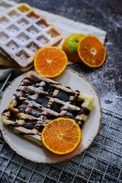 High angle view of waffles with oranges on table