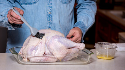 Buttery mixture is brushed on a raw turkey