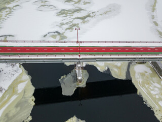 Pedestrian bridge over the Dnieper river in Kiev. Snow patterns on the river. Aerial drone view....