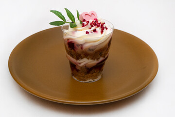 Trifle portioned mini cake on plate. Layered trifle dessert with whipped cream and chocolate hearts.