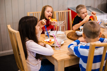 Children eating pizza enjoying the birthday party