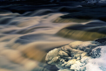Frozen and icy streams filled with cold spring water flowing through the rural countryside of South Eastern Ontario Canada, full scenic landscapes featuring natural phenomena.