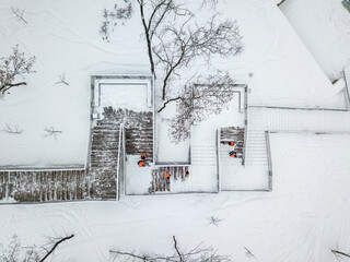 Cleaning the snowy stairs. Aerial drone view. Winter snowy day.