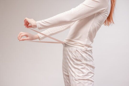 Beautiful sexy woman wearing a beige pajama. Fashion model on a beige background.