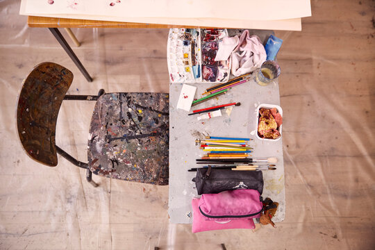 High angle view of art and craft equipment on table by chair