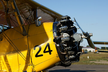 restored old yellow biplane with one engine per propeller