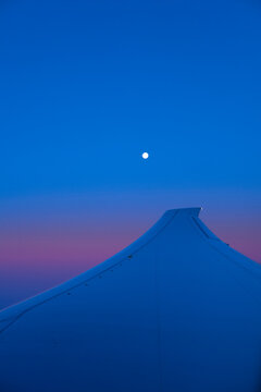 Close-up of airplane wing against dramatic sky during night