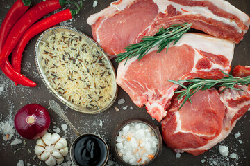 Raw meat with spices in a composition with kitchen accessories.