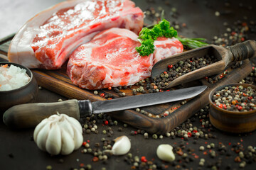 Raw meat with spices in a composition with kitchen accessories.
