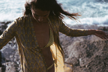 Dramatic front view of a woman in a bikini by the sea