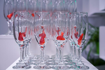 Table with glass goblets with strawberries for refreshing cocktails at the conference