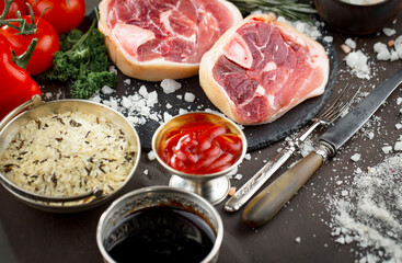 Raw meat with spices in a composition with kitchen accessories.