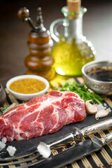 Raw meat with spices in a composition with kitchen accessories.