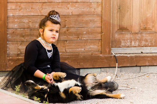 girl in costume from the movie breakfast with diamonds playing with dog