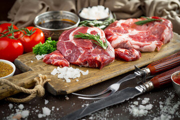 Raw meat with spices in a composition with kitchen accessories.