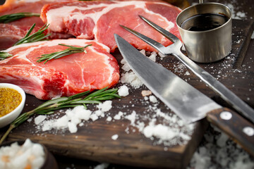 Raw meat with spices in a composition with kitchen accessories.
