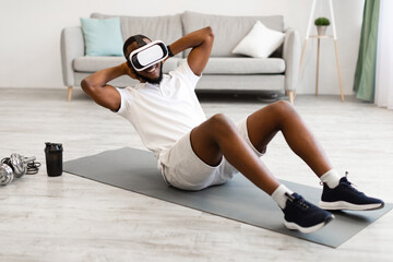 African Man Wearing VR Glasses Doing Abs Exercise At Home