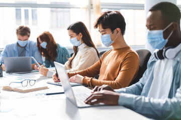 International people wearing medical face masks using laptop
