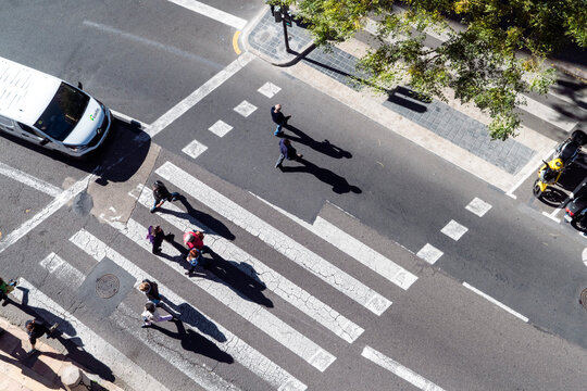 Zebra stribes, street traffic with people crossing from above